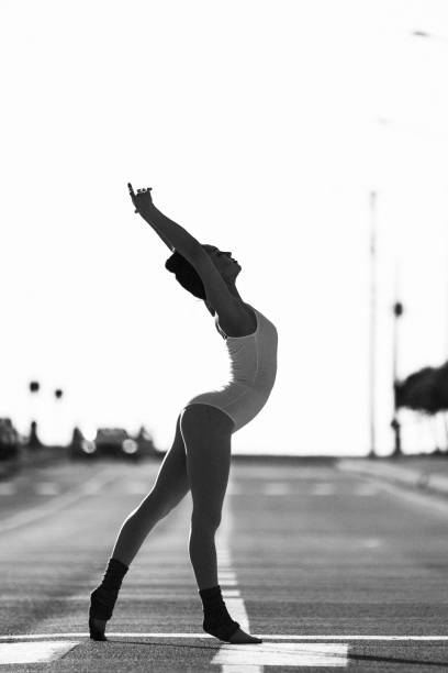 Beautiful ballet dancer posing at street