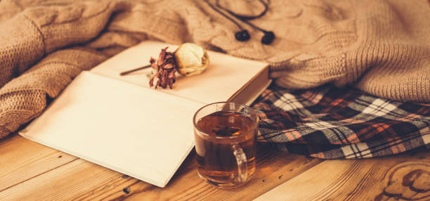 jesień tła. jesienna kompozycja z gorącą herbatą, książką, suchym kwiatem róży i dzianinowym swetrem. filiżanka gorącej herbaty, dzianinowy szalik na drewnianym stole. - dry leaves audio zdjęcia i obrazy z banku zdjęć