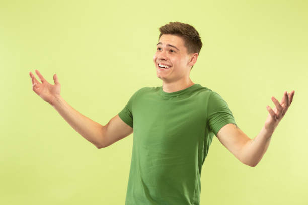 istock Caucasian young man's half-length portrait on green background 1177062255