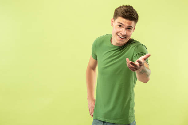 istock Caucasian young man's half-length portrait on green background 1177062261