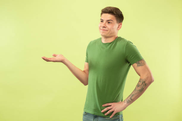 istock Caucasian young man's half-length portrait on green background 1177062280