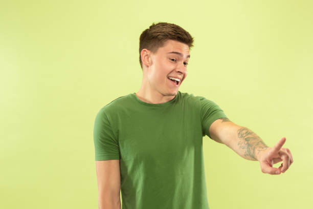 istock Caucasian young man's half-length portrait on green background 1177062288