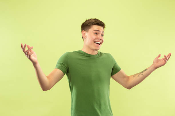 istock Caucasian young man's half-length portrait on green background 1177062352