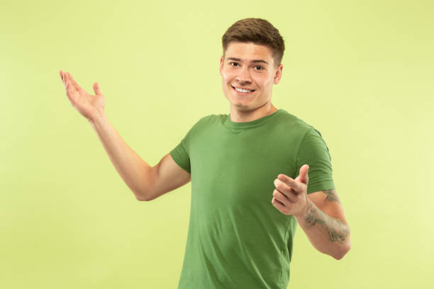 istock Caucasian young man's half-length portrait on green background 1177062354