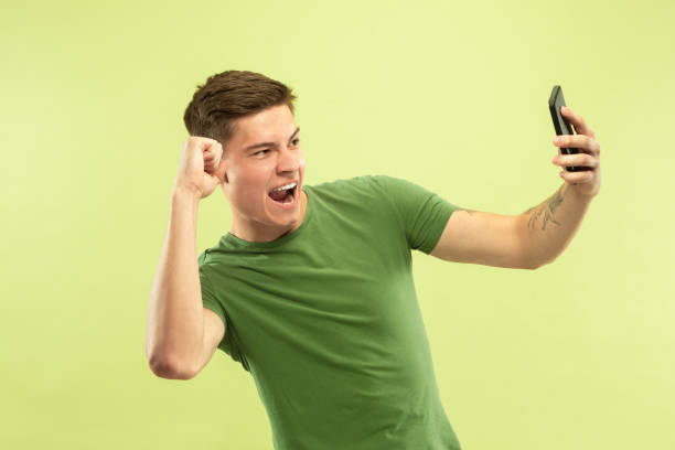 istock Caucasian young man's half-length portrait on green background 1177062393