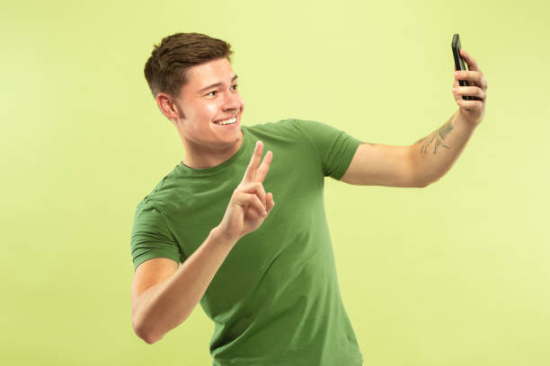 istock Caucasian young man's half-length portrait on green background 1177062422