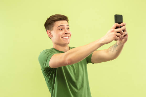 istock Caucasian young man's half-length portrait on green background 1177062432
