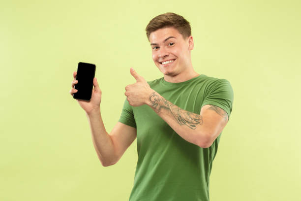 istock Caucasian young man's half-length portrait on green background 1177062492
