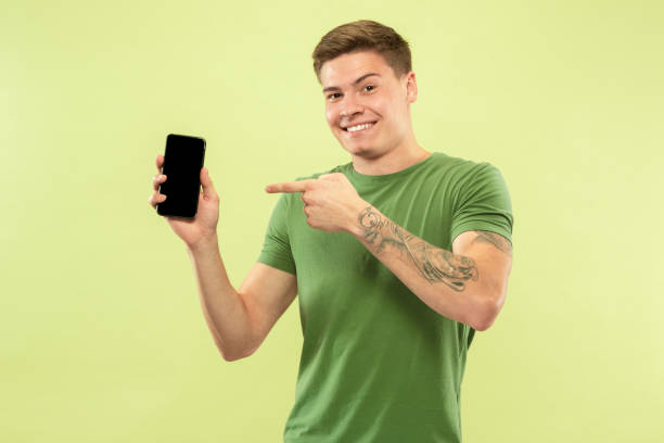 istock Caucasian young man's half-length portrait on green background 1177062495