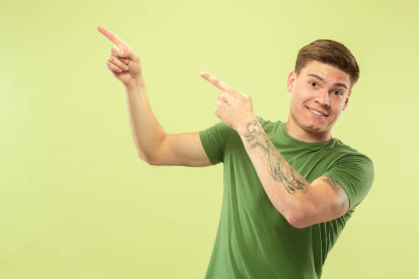 istock Caucasian young man's half-length portrait on green background 1177062903