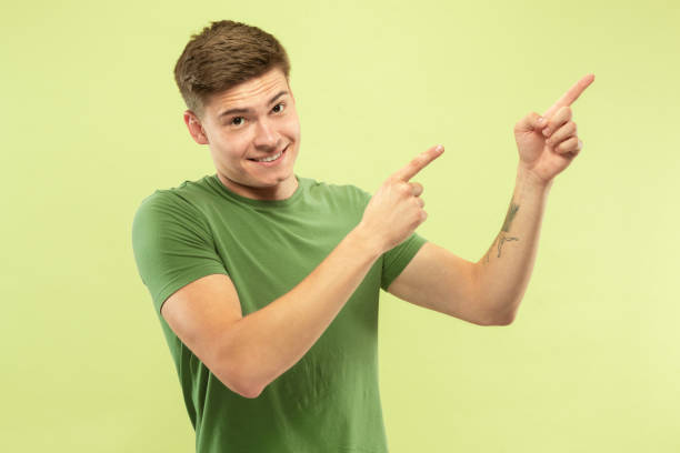 istock Caucasian young man's half-length portrait on green background 1177062930