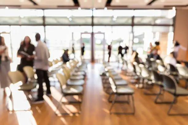 Photo of Unfocused photo of expo auditorium with unrecognizable people