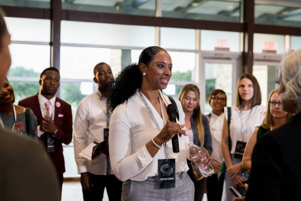 istock Mid adult woman with microphone asks expo speaker question 1177065328