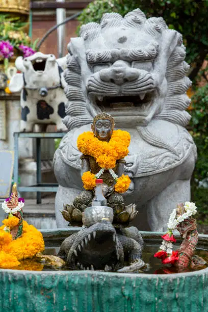 Photo of Woman statue beckoning happy with yellow flower in Thai temple, focus selective.