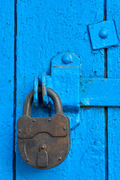 istock Old closed padlock on wooden weathered door 1177069102