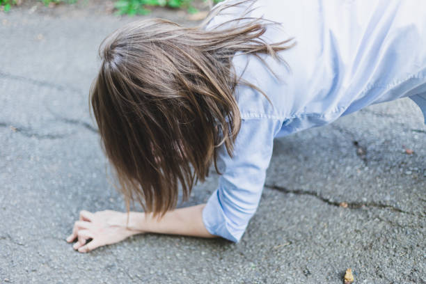 mujer joven con problemas cardíacos tumbado en la calle mirando hacia abajo - human hand help pain heart attack fotografías e imágenes de stock