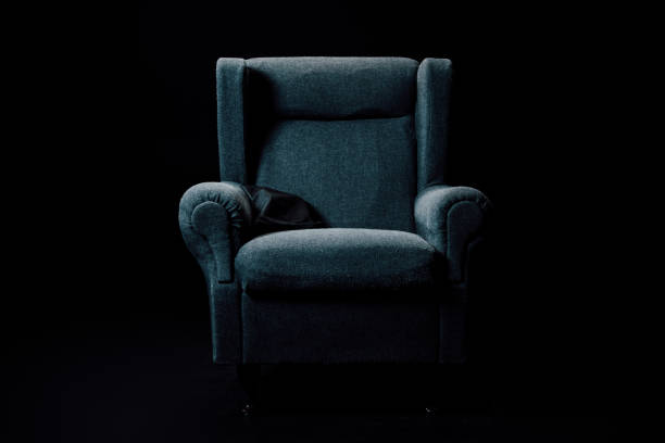 A close up and detailed image of leather sofa chair or couch, accented with buttons. Matching damask wallpaper in the background.  Horizontal image with copy space.