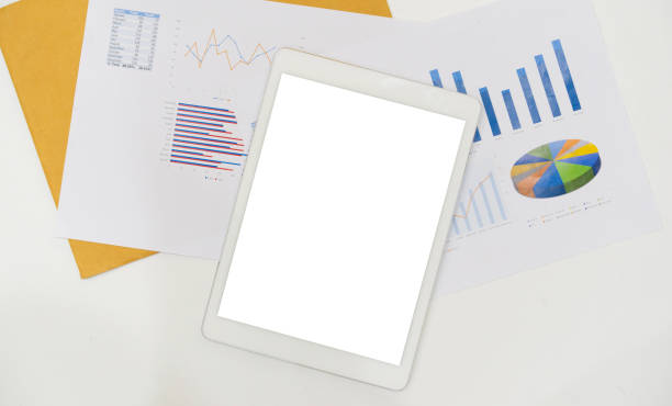 istock close up top view of digital tablet with white screen lay on statistic graph and chart summary report to show the company profit in the meeting event at conference room , business financial and marketing  strategy concept 1177080641
