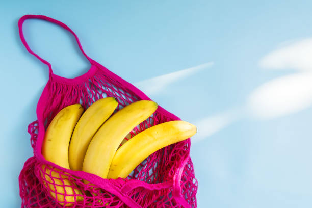 istock Organic banana in mesh string bag on pastel blue background. Flat lay, top view. Zero waste, plastic free concept. Healthy clean eating diet and detox 1177081969