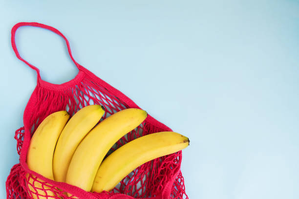 istock Organic banana in mesh string bag on pastel blue background. Flat lay, top view. Zero waste, plastic free concept. Healthy clean eating diet and detox 1177081979