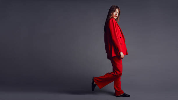 istock Young woman in red suit. Grey background 1177082097
