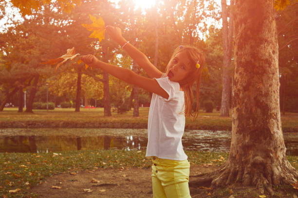 istock Young girl holding autumn leafs in nature. 1177085533