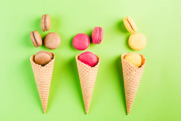 istock Multicolored macaroons in a waffle cone on a green and yellow background, top view, Flatley with copy space 1177087574