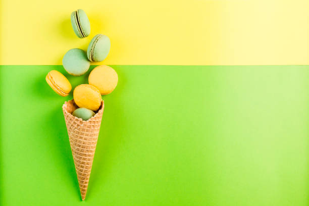 istock Multicolored macaroons in a waffle cone on a green and yellow background, top view, Flatley with copy space 1177088594