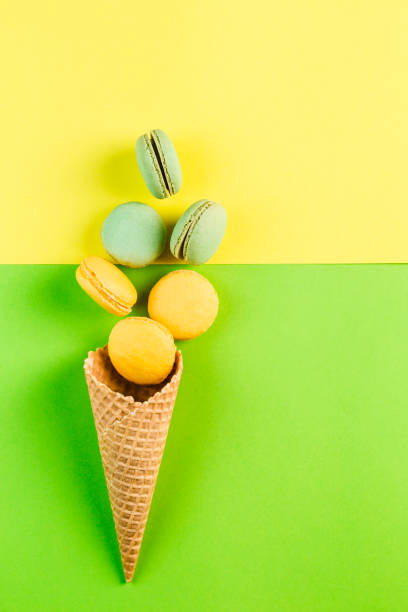 istock Multicolored macaroons in a waffle cone on a green and yellow background, top view, Flatley with copy space 1177088649