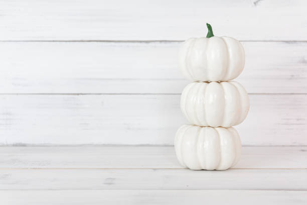 Stack of white pumpkin on white wood table with copy space.
