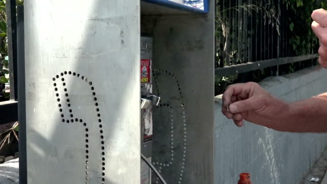 Man putting coins in a pay phone