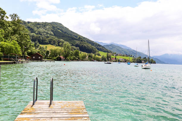 vista sul lago attersee con barca a vela, montagne delle alpi austriache vicino a salisburgo, austria europa - upper austria foto e immagini stock