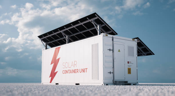 istock Solar container unit. 3d rendering concept of a white industrial battery energy storage container with mounted black solar panels situated on white gravel in empty landscape in sunny weather. 1177095704