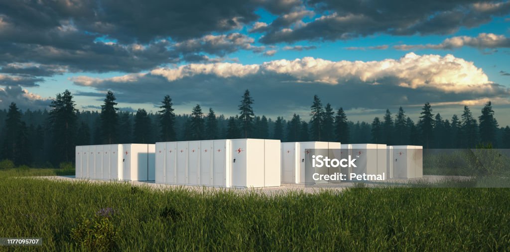 Eco friendly battery energy storage system in nature with misty forest in background and fresh grassland in foreground. 3d rendering. Battery Stock Photo