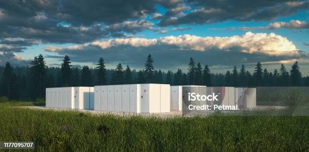 Eco Friendly Battery Energy Storage System In Nature With Misty Forest In Background And Fresh Grassland In Foreground 3d Rendering Stock Photo - Download Image Now