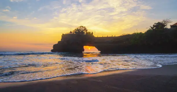 Photo of Rock cliff near Pura Tanah Lot, in Bali at sunset. It is one of the most popular of tourist attraction. Indonesia. Nature landscape background of travel trip and holidays vacation in Indonesia.