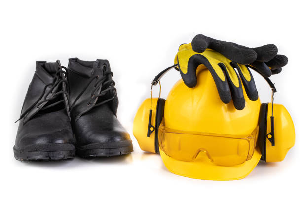 istock Helmet, boots and work gloves on a white table. Workwear for the production worker. Autumn Background. 1177104321