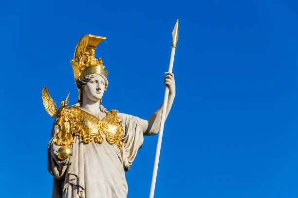 5 m tall statue of the Goddess of Wisdom, Athena, dressed in armor with a gilded helmet, her left-hand carries a spear, her right carries Nike. Athena stands on a pillar. Athena or Pallas Athena in Greek, or Minerva, in Roman mythology the goddess of war, civilization, wisdom. She is often depicted with an owl, which symbolizes her ties to wisdom.