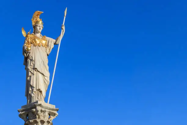 5 m tall statue of the Goddess of Wisdom, Athena, dressed in armor with a gilded helmet, her left-hand carries a spear, her right carries Nike. Athena stands on a pillar. Athena or Pallas Athena in Greek, or Minerva, in Roman mythology the goddess of war, civilization, wisdom. She is often depicted with an owl, which symbolizes her ties to wisdom.