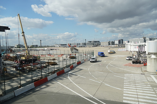 Paris Charles de Gaulle Airport, Paris, France, view on runway, service vehicles are visible, no people.