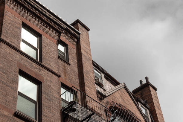 istock Top edge of old brownstone apartments on a cloudy way 1177107407