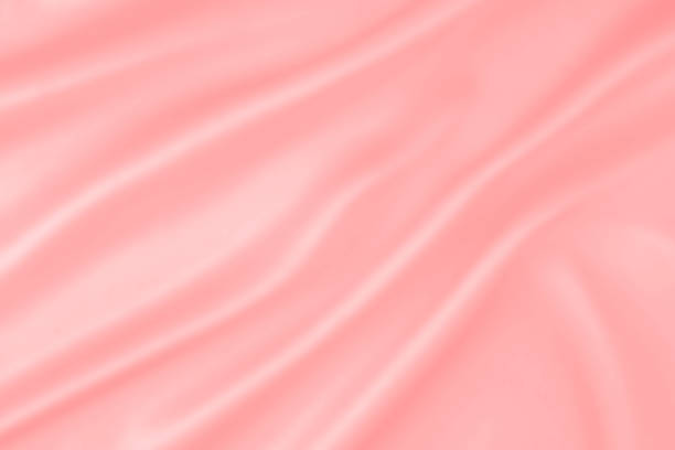 istock Pink colored soft satin silk wrinkled abstract background with soft waves. Artistic red pink soft silk fabric smooth wavy background. 1177109164