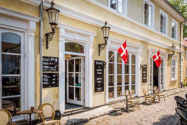 An old idyllic danish restaurant with chairs and tables on the pavement in Aeroskobing, Denmark, July 13, 2019