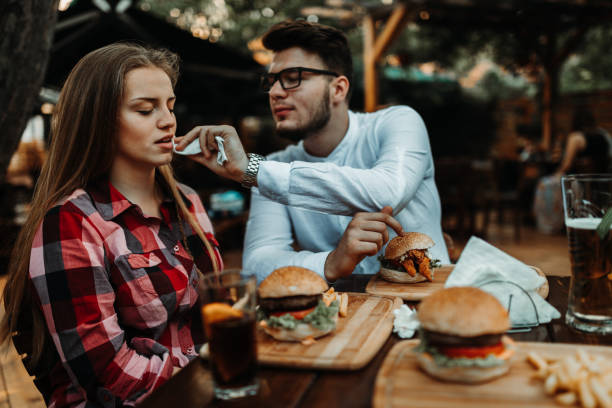 istock Smiling boyfriend and girlfriend eating hamburgers 1177110547