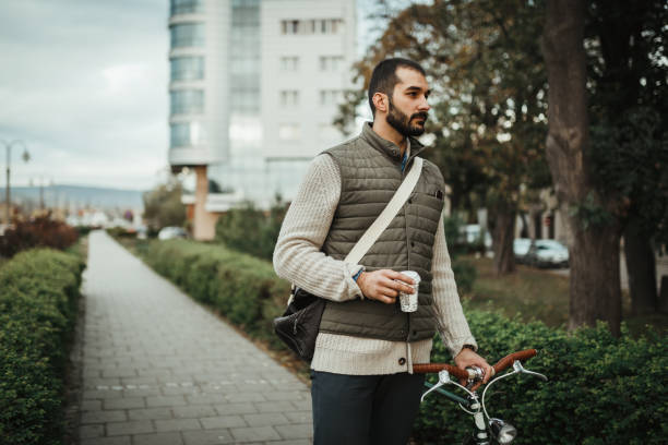 Man with a bicycle drinking coffee in the park