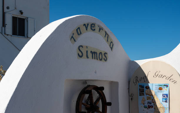 znak dla restauracji taverna simos z dekoracją koła statku w fira centre - log fire zdjęcia i obrazy z banku zdjęć