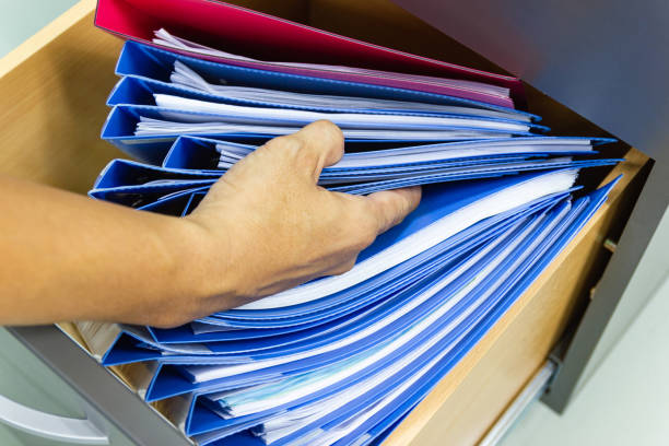 istock Hand of Man Search files document in a file cabinet in work office 1177116094