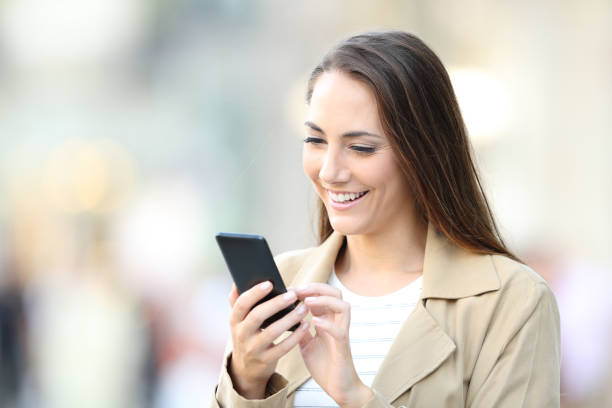 istock Happy casual lady using cell phone in the street 1177119664