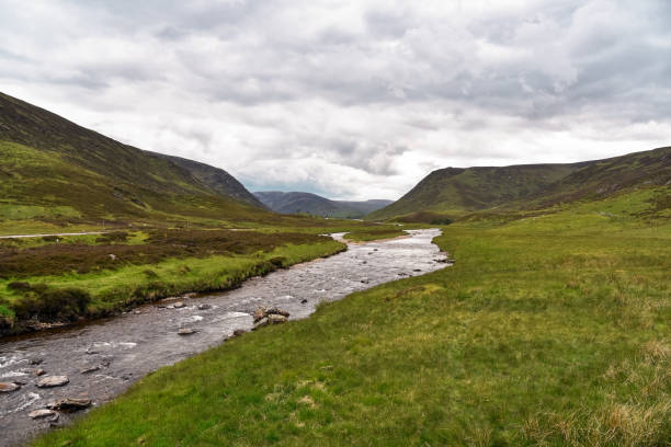 istock River flowing through grassy mountains on an overcast summer day 1177119707