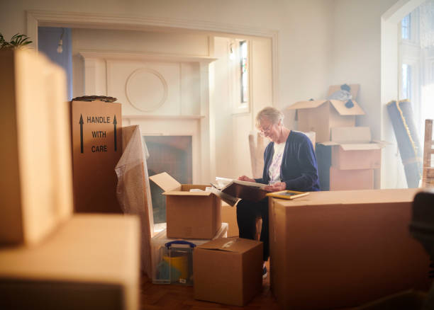 fond house memories senior woman looks through some memories just before the house move begins belongings stock pictures, royalty-free photos & images